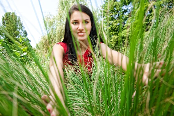 Femme peering à travers l'herbe — Photo