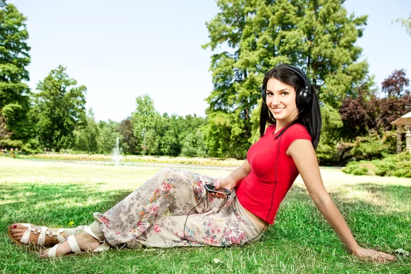 Meisje met koptelefoon in het park — Stockfoto