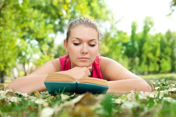 Meisje met boek in park — Stockfoto