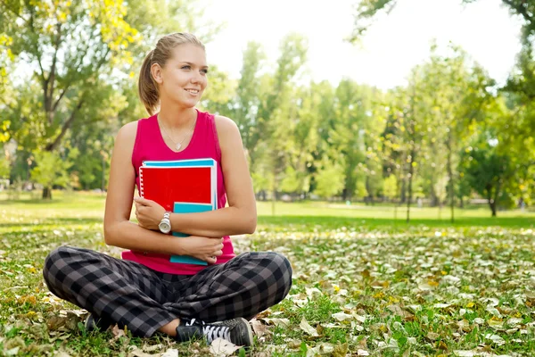 Student in park hugging books — Stock Photo, Image