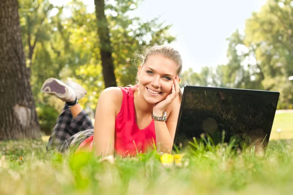 Девушка и ноутбук в парке — стоковое фото