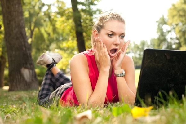 Surprised girl in front of laptop — Stock Photo, Image