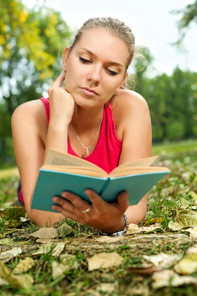 Mladá dívka čtení knih v parku — Stock fotografie