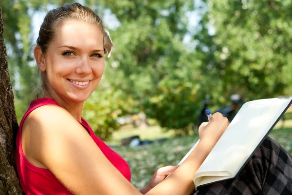 Menina sorridente com caderno — Fotografia de Stock