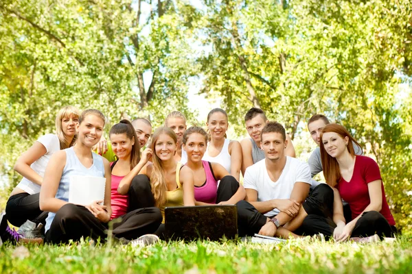 Jóvenes estudiantes con portátil al aire libre — Foto de Stock