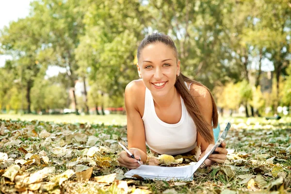Smiling student girl in park — Stock Photo, Image