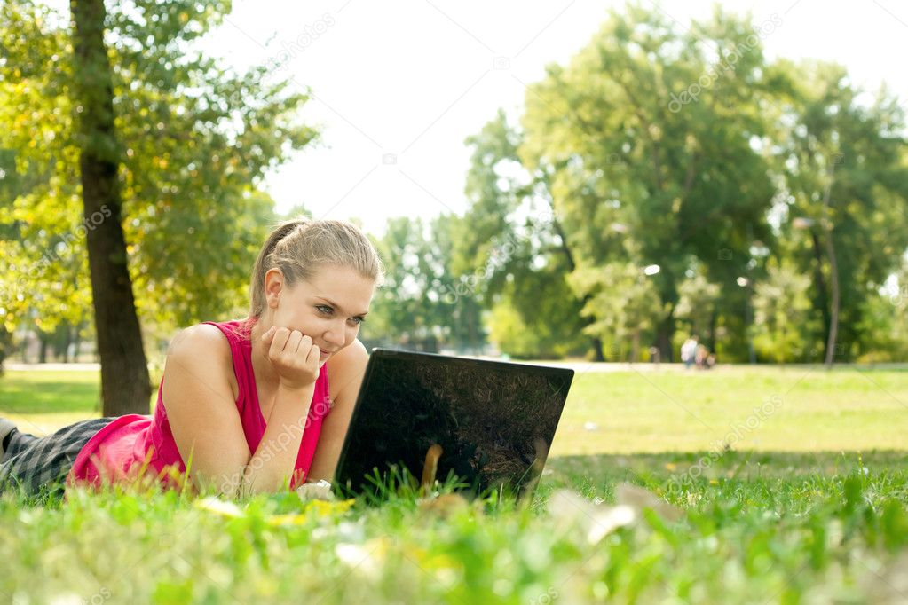 Women using laptop in park