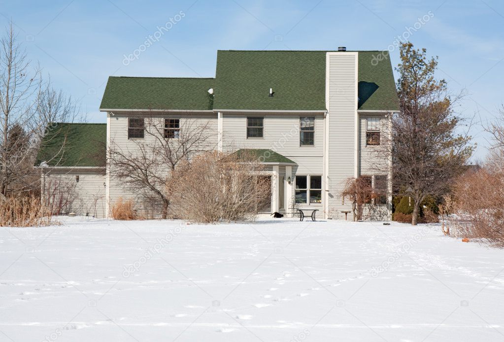 Back of a house and yard in snow