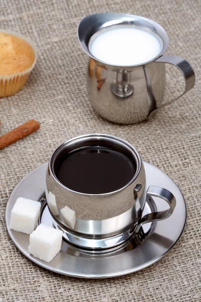 Xícara de café preto com muffin, leite e canela — Fotografia de Stock