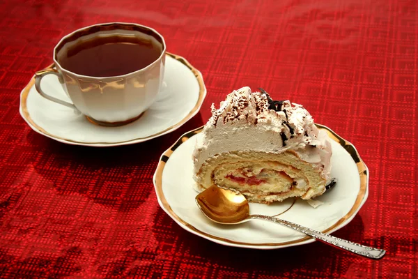 Tasse de thé avec la cuillère et une tranche de tarte sur fond rouge — Photo