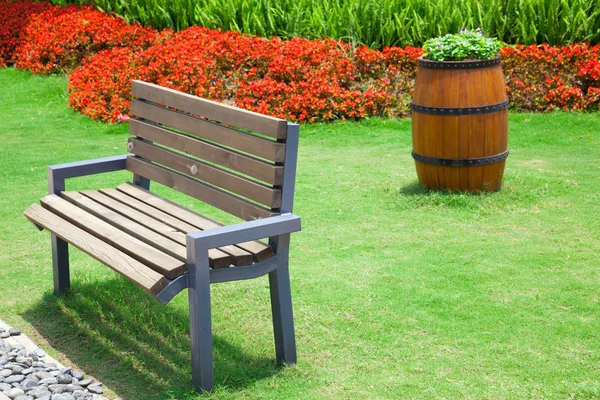 Летний сад со скамейкой и большим декоративным деревянным флигелем — стоковое фото