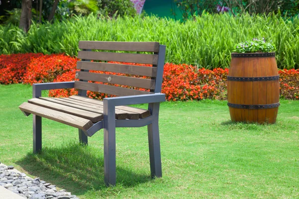 Piękny letni ogród z ławki i duże ozdobne drewniane flo — Zdjęcie stockowe