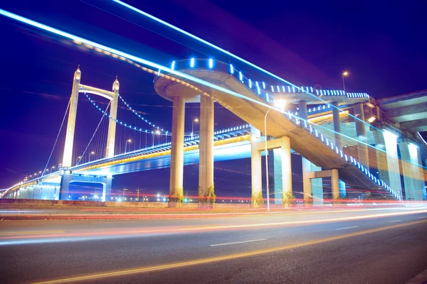 Світлові стежки на сучасному фоні підвісного мосту — стокове фото