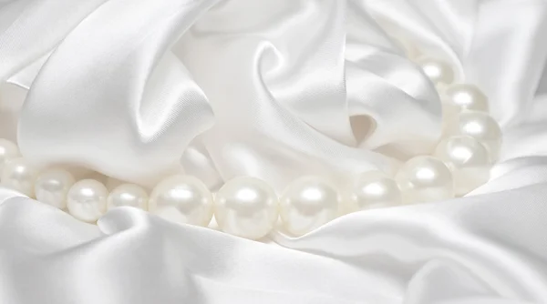 Perlas un collar en una tela de seda —  Fotos de Stock