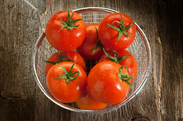 Tomates sobre fundo de madeira — Fotografia de Stock