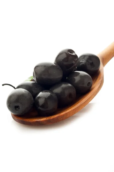 Svarta oliver över sked — Stockfoto