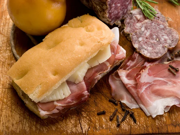Focaccia com salame de presunto e queijo sobre tábua de corte — Fotografia de Stock