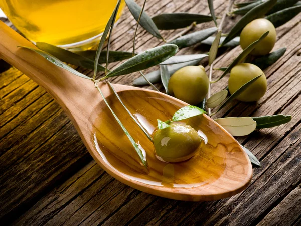 Olive oil over wood spoon — Stock Photo, Image