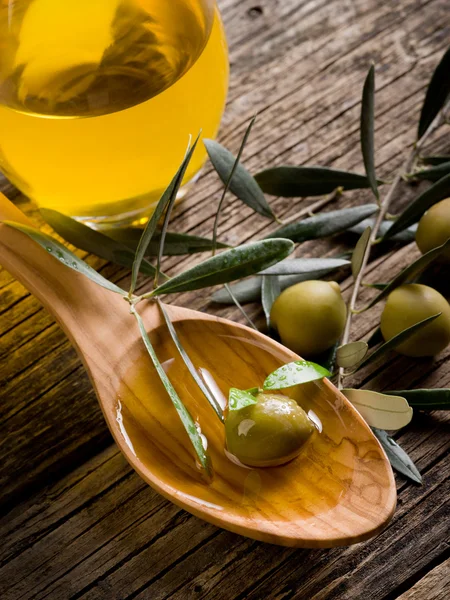Olivový olej nad dřevěnou lžící — Stock fotografie