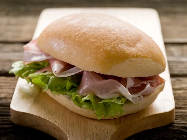 Sandwich with parma ham and green salad — Stock Photo, Image