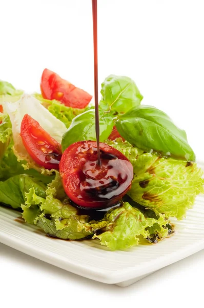 Бальзамический уксус над салатом — стоковое фото