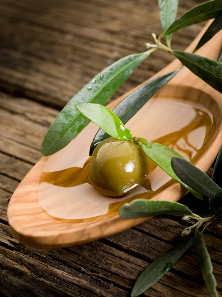 Оливковое масло над деревянной ложкой — стоковое фото