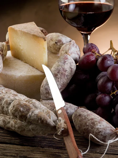Hrozny salám sýr a červené víno — Stock fotografie
