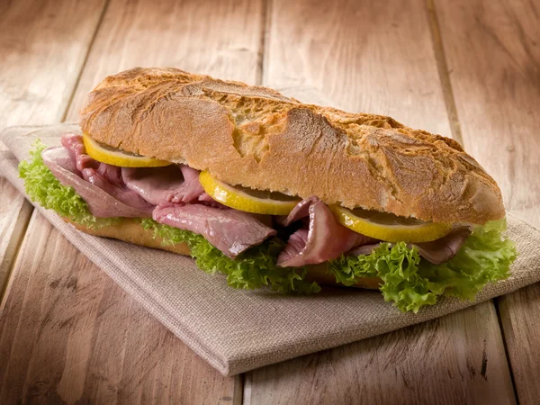 Sandwich with roastbeef lettuce and slice lemon — Stock Photo, Image