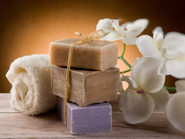 Натуральное мыло с полотенцем и цветами — стоковое фото