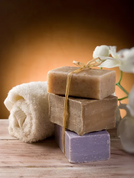 Натуральное мыло с полотенцем и цветами — стоковое фото