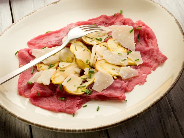Rindfleisch-Carpaccio mit Scheiben Eierpilz und Parmesanflocken — Stockfoto