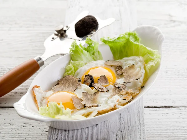Ovos com trufa sobre salada verde — Fotografia de Stock