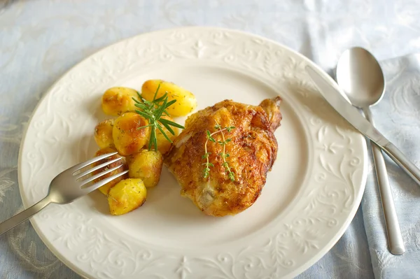 Chicken leg with roasted potatoes — Stock Photo, Image
