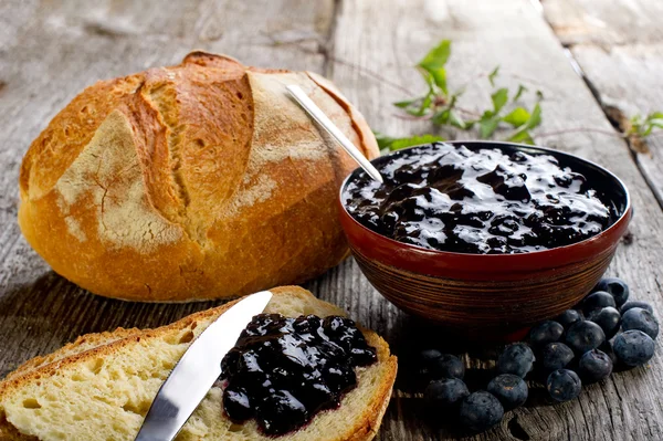 Blaubeermarmelade mit Brot auf Holz-Hintergrund — Stockfoto