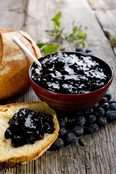 Blueberry jam with bread on wood background — Stock Photo, Image
