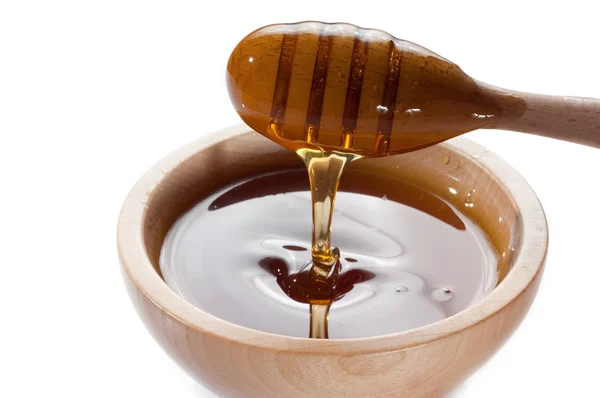 Honey on wood bowl Stock Photo