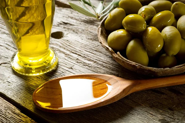 Huile d'olive sur fond de bois — Photo
