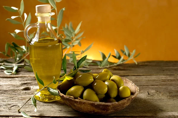 Olive oil on wood background — Stock Photo, Image