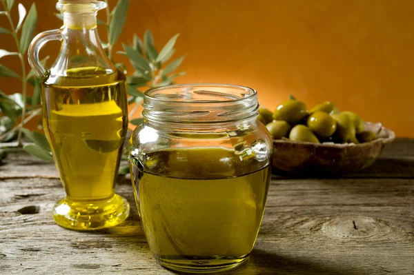 Olive oil on wood background — Stock Photo, Image