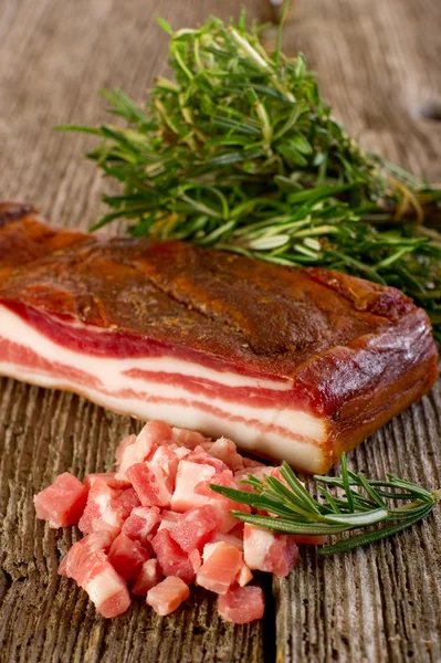 Bacon de fatia com alecrim sobre fundo de madeira — Fotografia de Stock