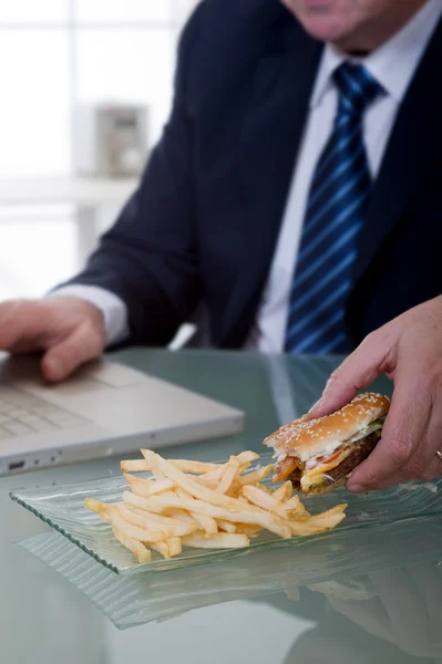 Manager working and eating unhealthy food — Stock Photo, Image