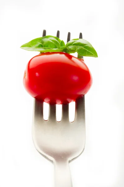 Garfo com tomate e manjericão — Fotografia de Stock