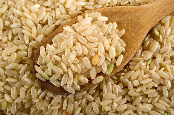 Tahta kaşık üzerine tüm pirinç — Stok fotoğraf