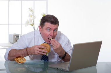 Manager eating unhealthy food at work place clipart