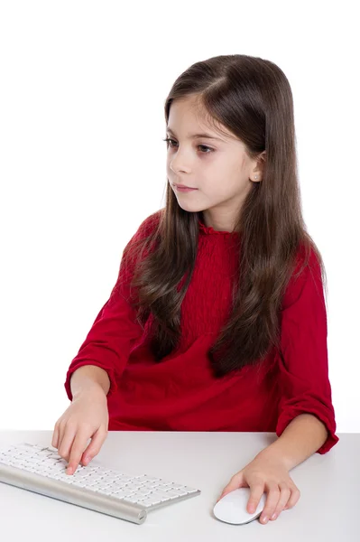 Concentrated little girl with Pc keyboard and mouse — Stock Photo, Image