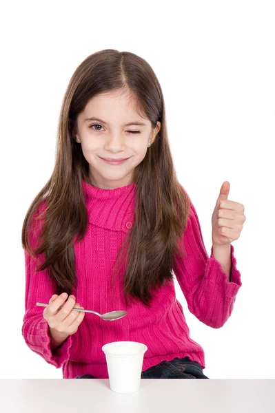 Маленькая девочка ест йогурт — стоковое фото