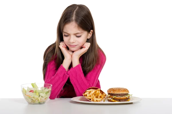 Meisje met gezonde en ongezonde voeding — Stockfoto
