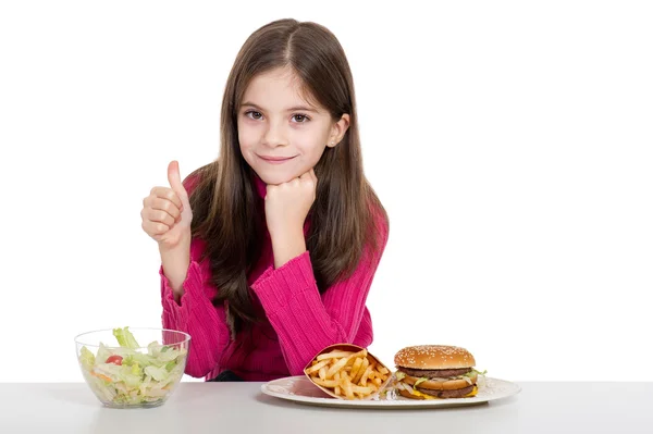 Little girl with healthy and unhealthy food — Stock Photo, Image