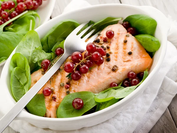 Grilled salmon with redcurrants and fresh spinach — Stock Photo, Image