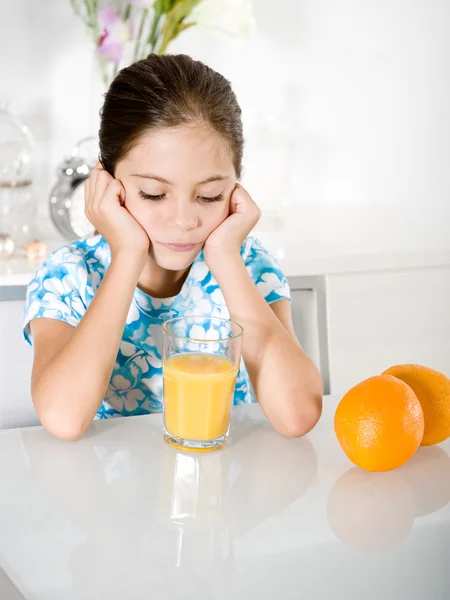 Menina entediada com suco de laranja — Fotografia de Stock